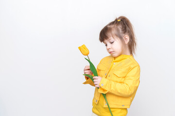 sad child girl in yellow clothes with yellow flowers