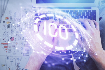 Double exposure of man's hands typing over computer keyboard and crypto currency theme hologram drawing. Top view. Blockchain concept.