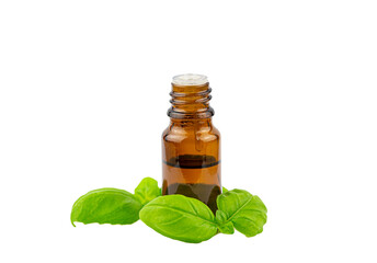 Basil Ocimum basilicum essential oil bottle with green basil leaf next to it, isolated on white background, lot of copy space, studio shot.