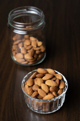 Pile of peeled raw almonds in a bowl on a wooden table