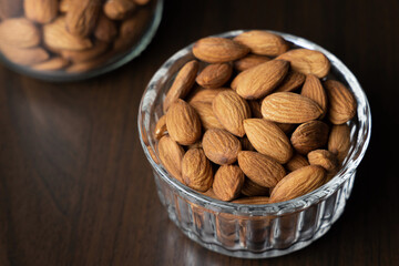 Pile of peeled raw almonds in a bowl on a wooden table