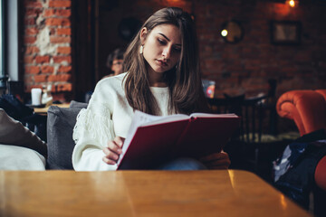 Focused woman reading information in notebook