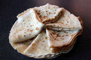 Thin pancakes, folded corners on a plate.