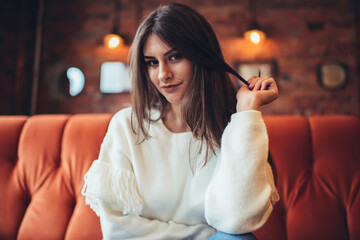 Smiling woman touching hair in cafe