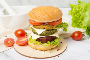 vegan burger served on cutting board over white rustic table.