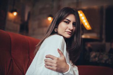 Pensive woman on sofa touching arm