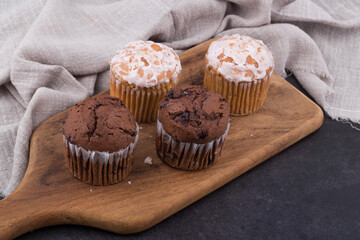 Chocolate dark muffins on wooden plate close up.