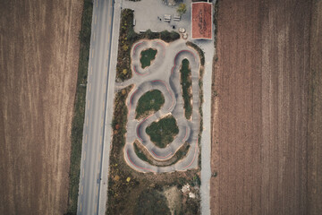 view of a pump track next to a road and two fields, top down, Schaffhausen, Switzerland, Europe