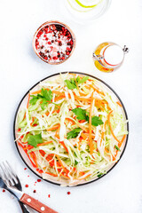 Salad coleslaw with cabbage, carrot on white kitchen table background. Top view, copy space