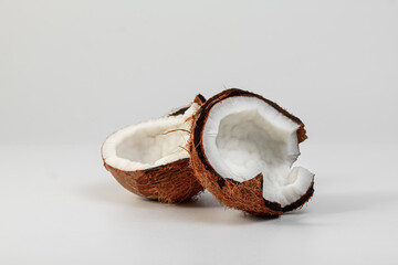 Tropical fruits. Two halves of a coconut on a light background. Healthy food concept.