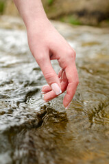female hand and stormy river. unity with nature. clear mountain river