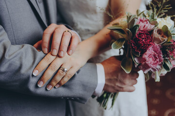 stylish bridal couple together, hands with wedding rings close up - 433033727