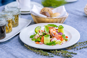 Salad with shrimp, grapefruit, cucumber, radish is served on a large white plate in the restaurant. Close-up. Restaurant menu.