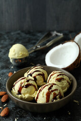 Bowl with ice cream balls and ingredients on black smokey table