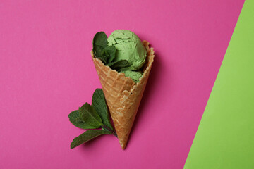 Cone of mint ice cream on two tone background