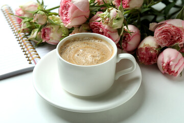 Roses, cup of coffee and copybook on white background