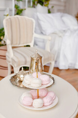 Living room in classic style. A coffee table decorated with flowers. silver teapot on a tray and marshmallows