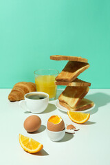 Concept of tasty breakfast with boiled eggs against mint background