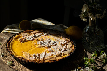 Freshly baked homemade lemon pie with floral crust decorations  in baking form on old wooden table...