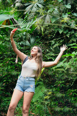 Beautiful woman taking a selfie with a cellular in a tropical forest