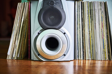 Vinyl records and loudspeaker box on hardwood floor © Nikamata