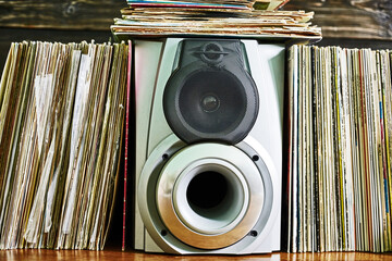 Vinyl records and loudspeaker box on hardwood floor © Nikamata