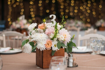table centerpiece with white and peach rustic floral arrangement in wood box. Rustic wedding table.