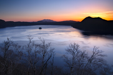 美しいグラデーションの夜明けの空と湖。日本の北海道の摩周湖。