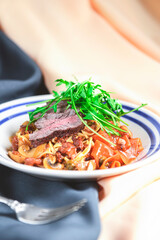 Creamy beef pasta made with egg noodles, beef, mushrooms and garnished with fresh rosemary and arugula.
