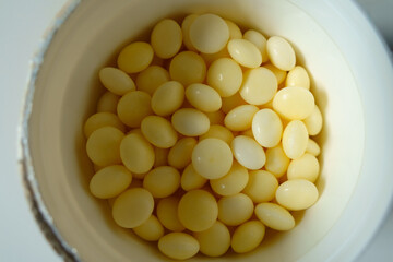 Bottle with round yellow xylitol mints from above