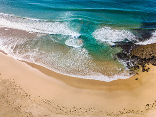Obraz premium Aerial view of a beach and rolling waves