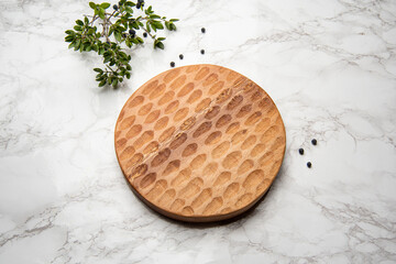 hand carved wooden cheeseboard on marble table