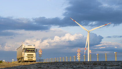 Truck driving on the highway, wind turbines near the road