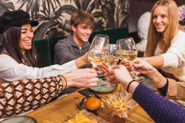 Group of smiling friends making a toast at a dinner party