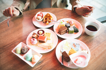 沢山のスイーツを食べる女性