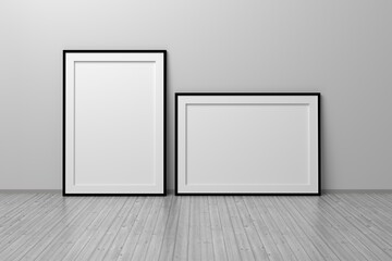 Two A4 blank empty frames vertical and horizontal standing on wooden floor in white room