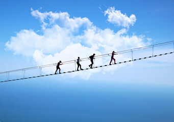 tourists walk on the suspension bridge in the clouds clouds