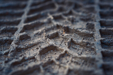 Wheel track on mud closeup. Tyre track on dirt, messy ground. Off road drive on dirty ground, bad road conditions. Car track on the ground. Imprint tires on wet clay. Dirt with traces from the wheel
