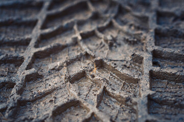 Wheel track on mud closeup. Tyre track on dirt, messy ground. Off road drive on dirty ground, offroad track. Car track on the ground. Imprint tires on wet clay. Dirt with traces from the wheels.
