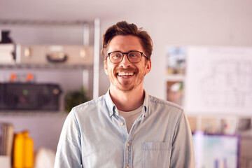 Portrait Of Smiling Male Architect In Office Standing By Desk