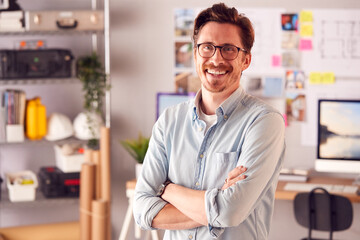 Portrait Of Smiling Male Architect In Office Standing By Desk
