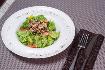 Tasty warm salad with veal on a table in a restaurant