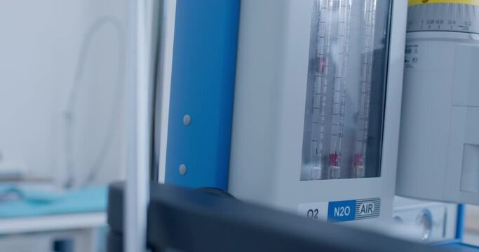 Close-up an anesthesia workstation with pipeline inlet pressure is standing at the medical room and someone is elevating the level of oxygen, air, nitrogen oxide.