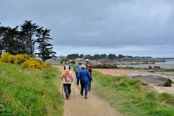 Fototapeta premium Senior hikers at Tregastel in Brittany. France