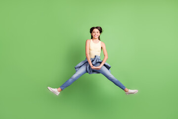 Full size photo of haapy beautiful cheerful good mood energetic girl jumping isolated on green color background