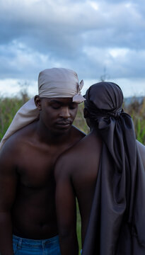 Young men in do-rags leaning on each other