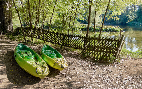 Two Green Canoe Kayaks By The River, Concept Of Watersports Training