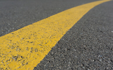 Fototapeta premium Gray asphalt road with yellow stripe