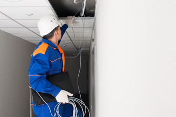 a worker performs technical work on setting up the Internet in homes and offices