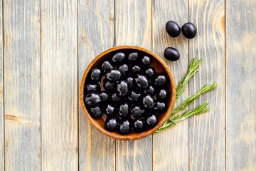 Black olives in wooden bowl. Overhead view